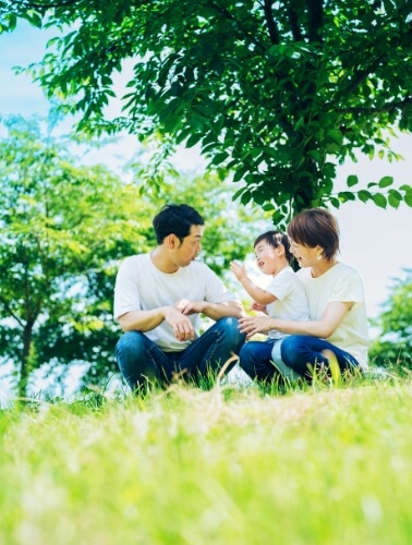 木の横で遊ぶ家族